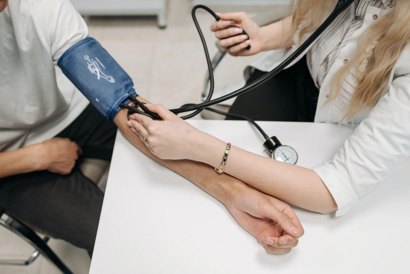 A clinician measuring a patient's blood pressure with a cuff