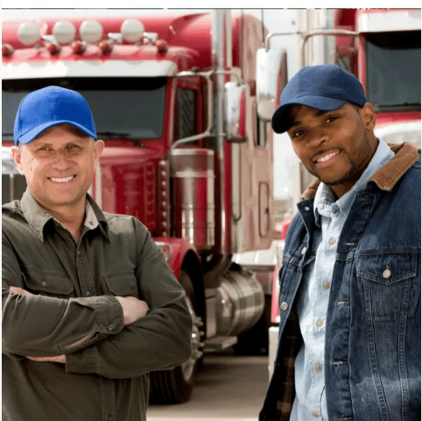 Two truck drivers smiling in front of their rigs