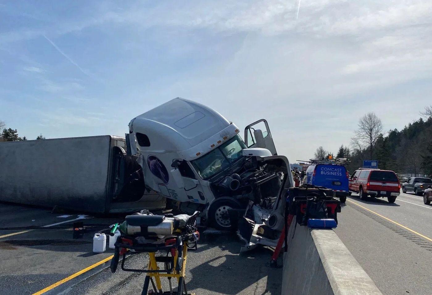 A semi truck involved in a highway crash with responders nearby